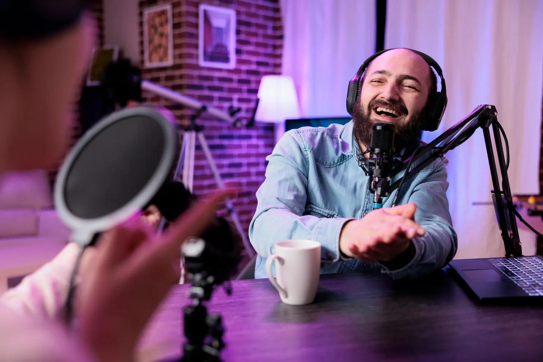 A podcaster laughing on air in his home studio